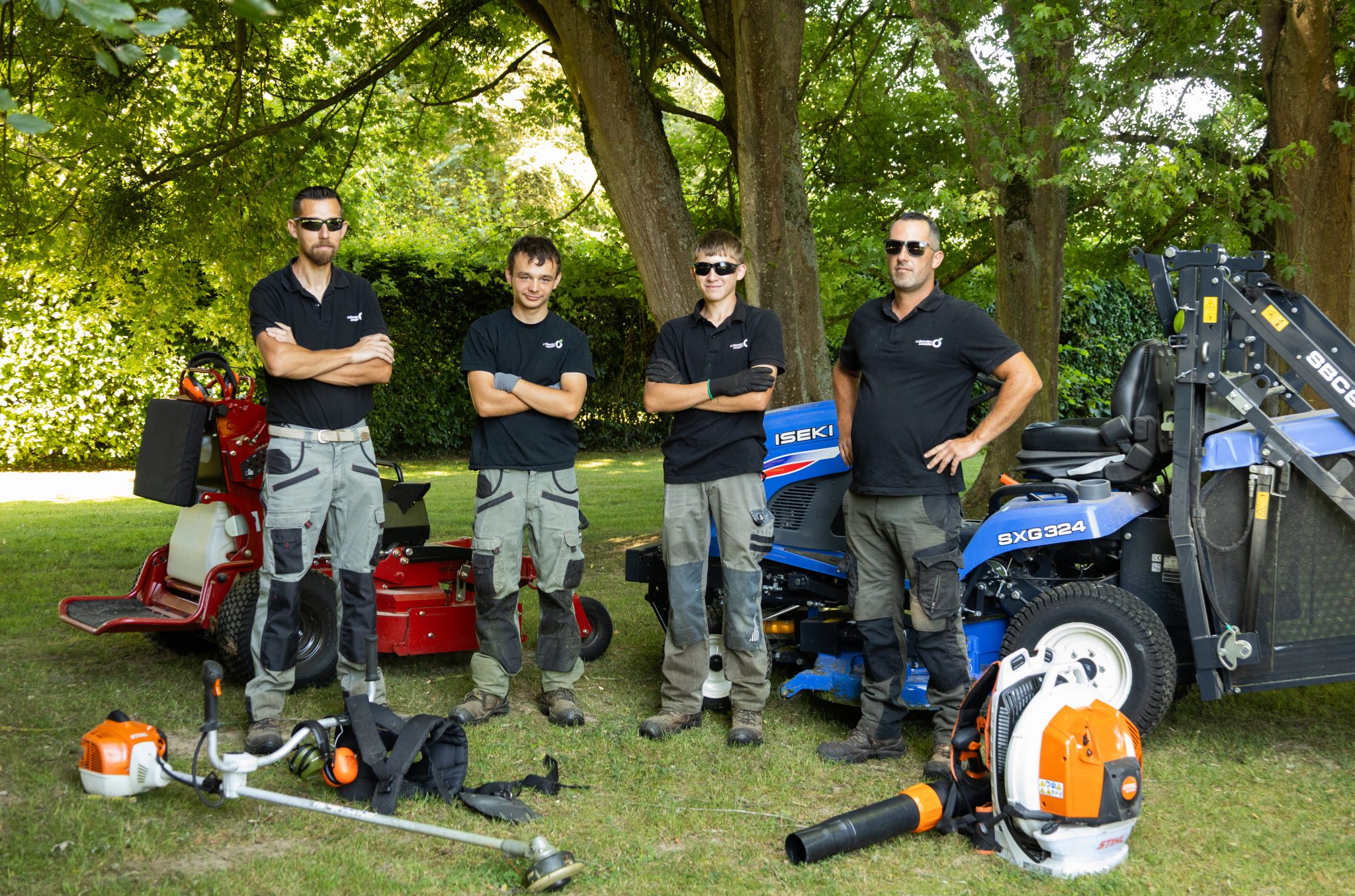 Quatre paysagistes CONFORT O JARDIN avec le micro-tracteur Iseki SXG 324, une tondeuse autoportée et du matériel STIHL