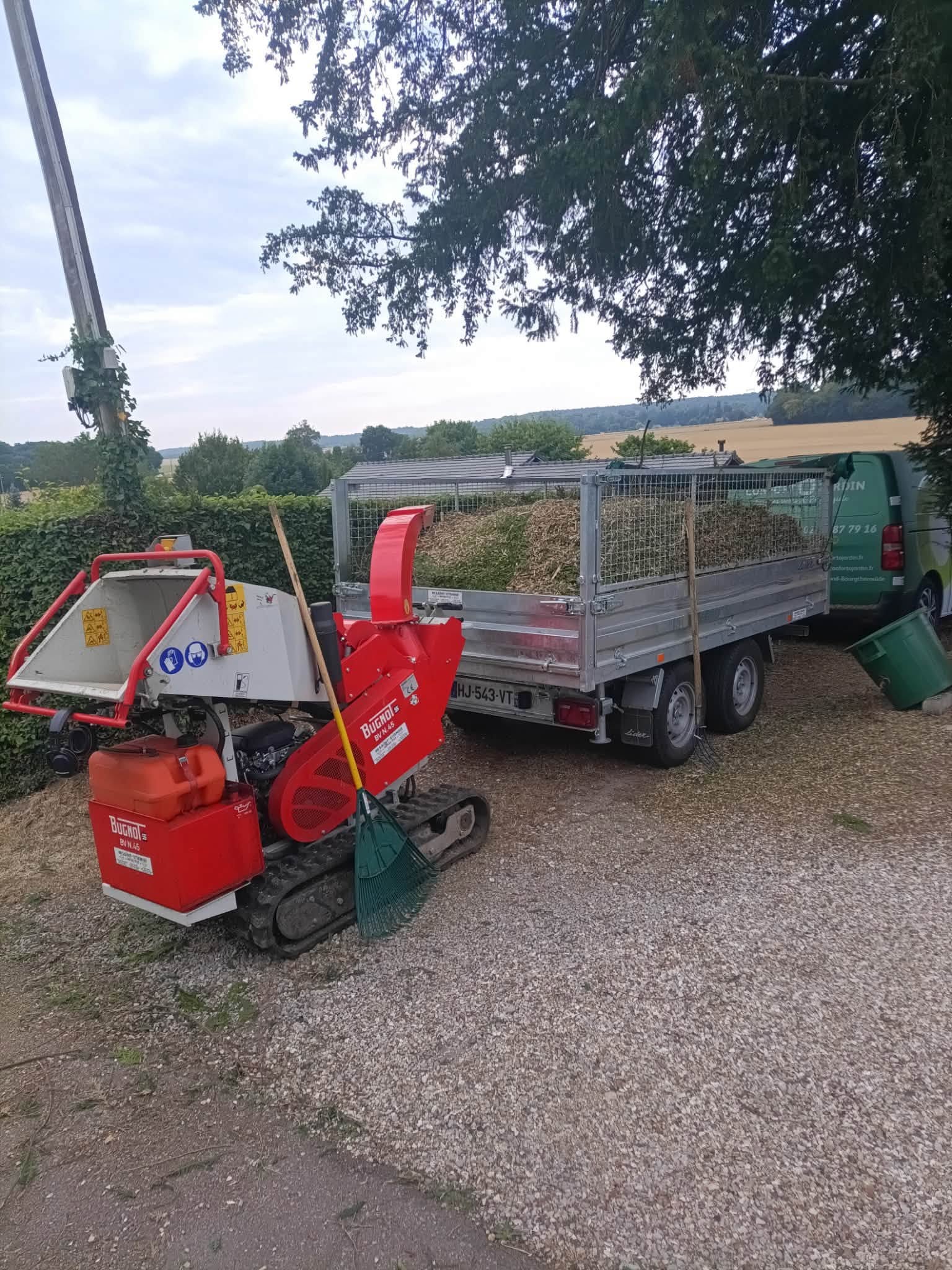 Broyeur à chenilles Bugnot et remorque chargée de branches broyées en fin de chantier