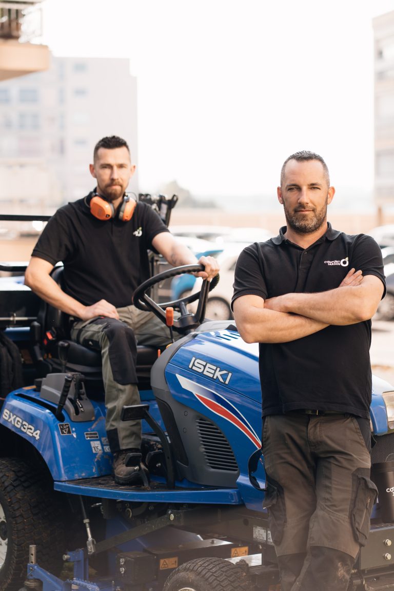 Stéphane assis sur la tondeuse autoportée ISEKI SXG324 et Benjamin Egret debout, bras croisés