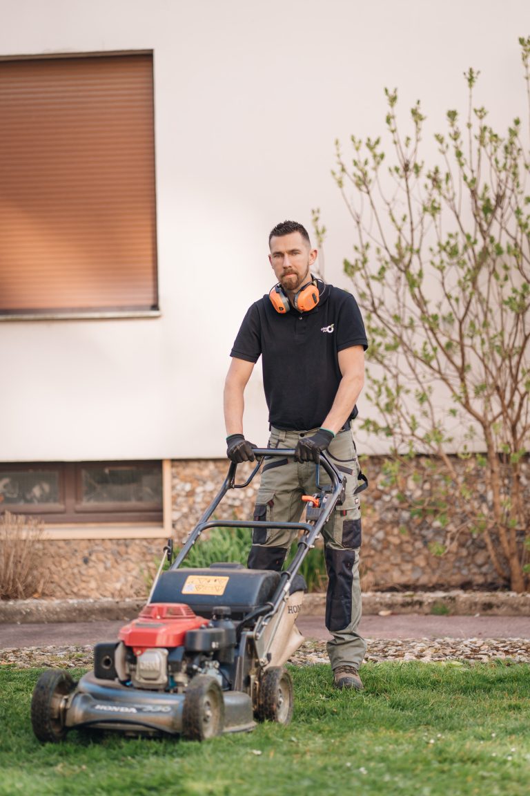 Stéphane tond une bande de pelouse au pied d’une maison avec une tondeuse thermique Honda