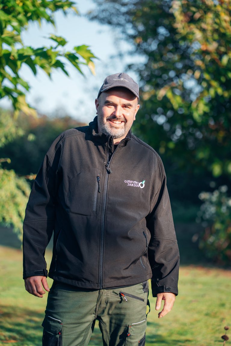 Renaud, chef d’équipe CONFORT O JARDIN, souriant dans un jardin au soleil d’automne