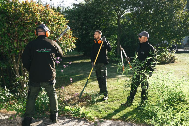Renaud, Benjamin Egret et Stéphane taillent, ratissent et évacuent les branchages dans un jardin