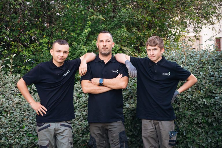 Yoni, Benjamin Egret et Louka, paysagistes CONFORT O JARDIN, posent devant une haie